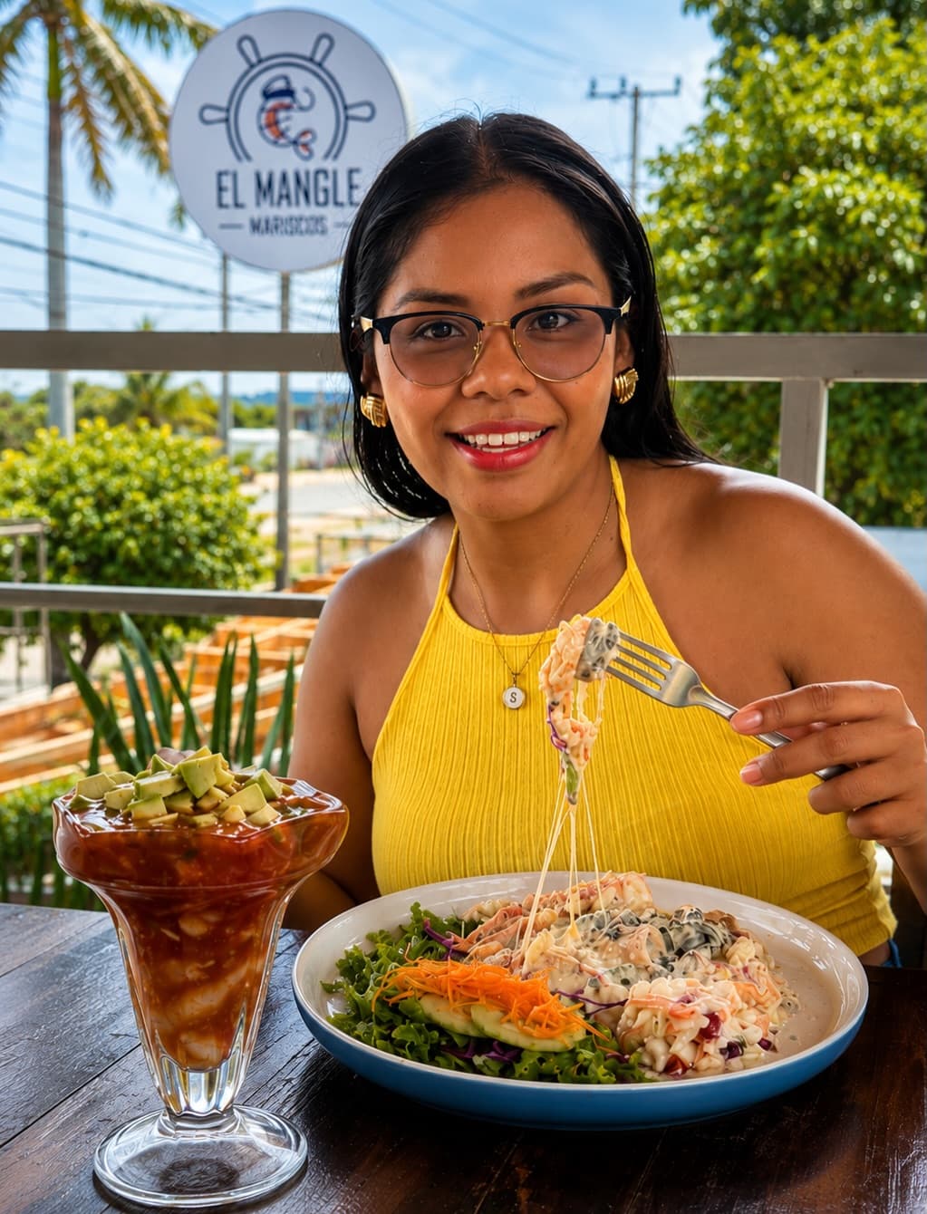 Una comensal con su plato y un cóctel de mariscos en la terraza