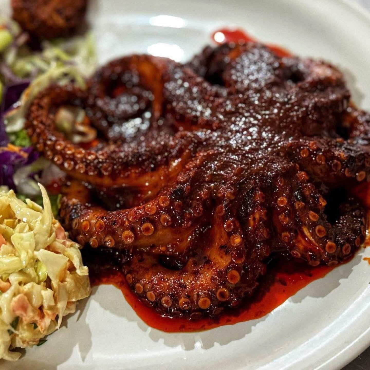 Pulpo en salsa roja con ensalada de col